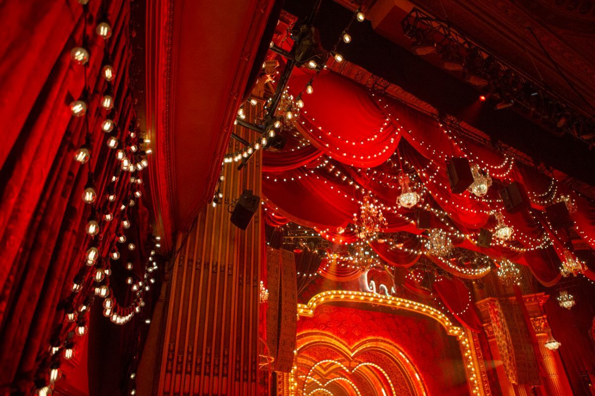 Reveal Productions’ red velvet drapery and chandeliers forming the opulent ceiling design for Moulin Rouge’s theatrical set.