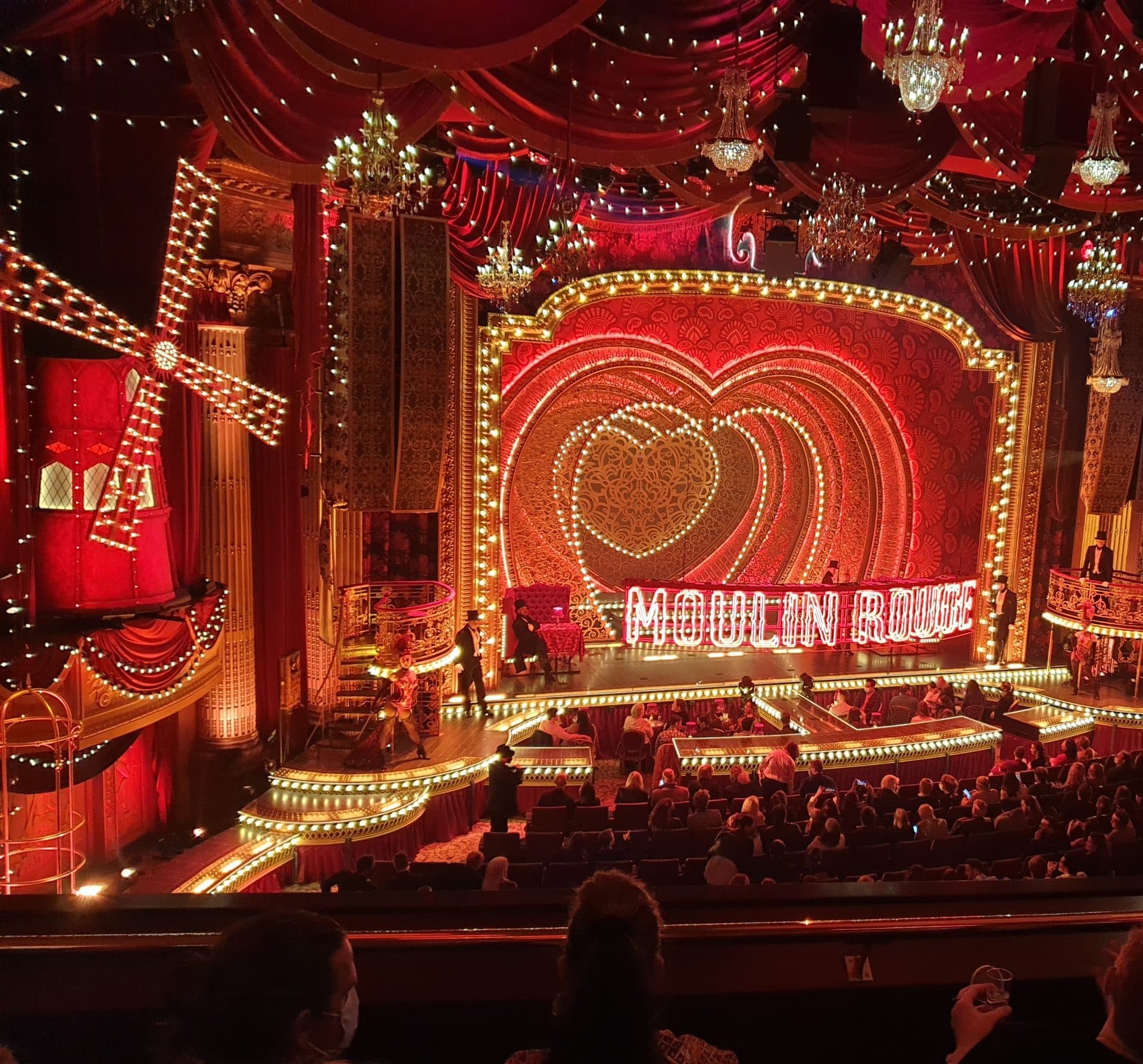Moulin Rouge! The Musical at Melbourne's Regent Theatre with windmill, heart portal and red swag drapes